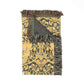 Decorative throw blanket with intricate patterns and fringes on a white background