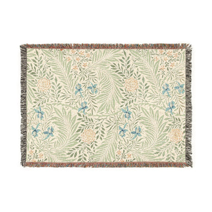 Floral patterned throw blanket with green leaves and blue flowers on a white background
