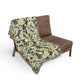Floral-patterned blanket draped over a brown chair on a white background