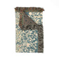 Decorative rug with floral pattern and fringed edge on a white background