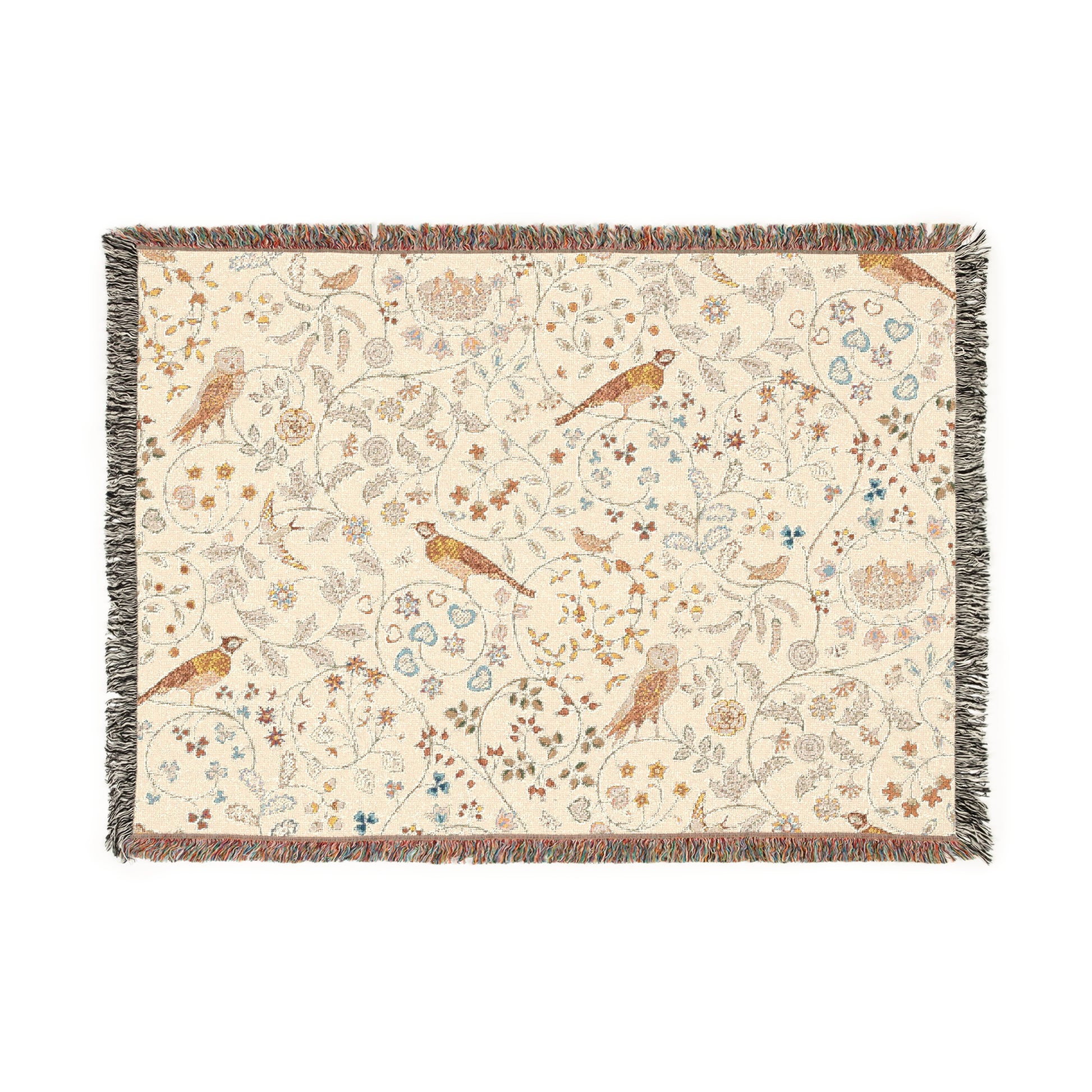A beige woven cotton blanket with a William Morris & Co floral and bird pattern, featuring a colourful fringed edge.