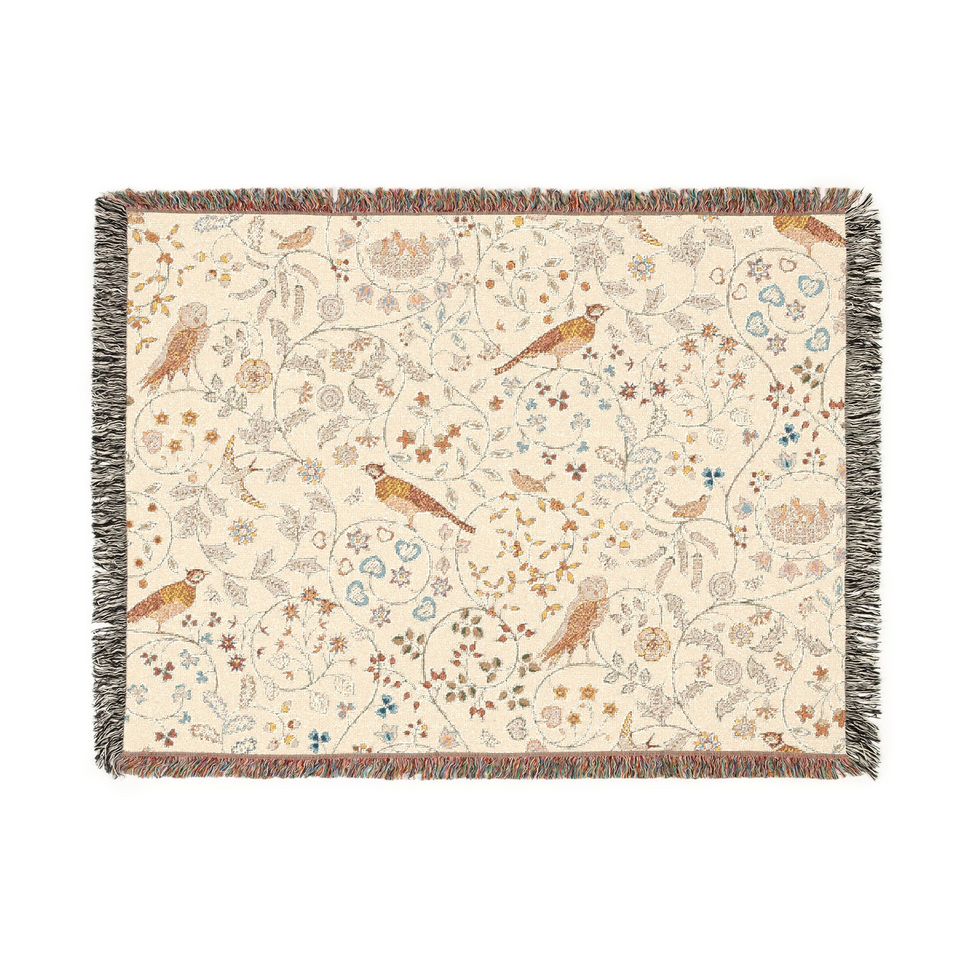 A beige woven cotton blanket with a floral and bird pattern, featuring a colorful fringed edge.