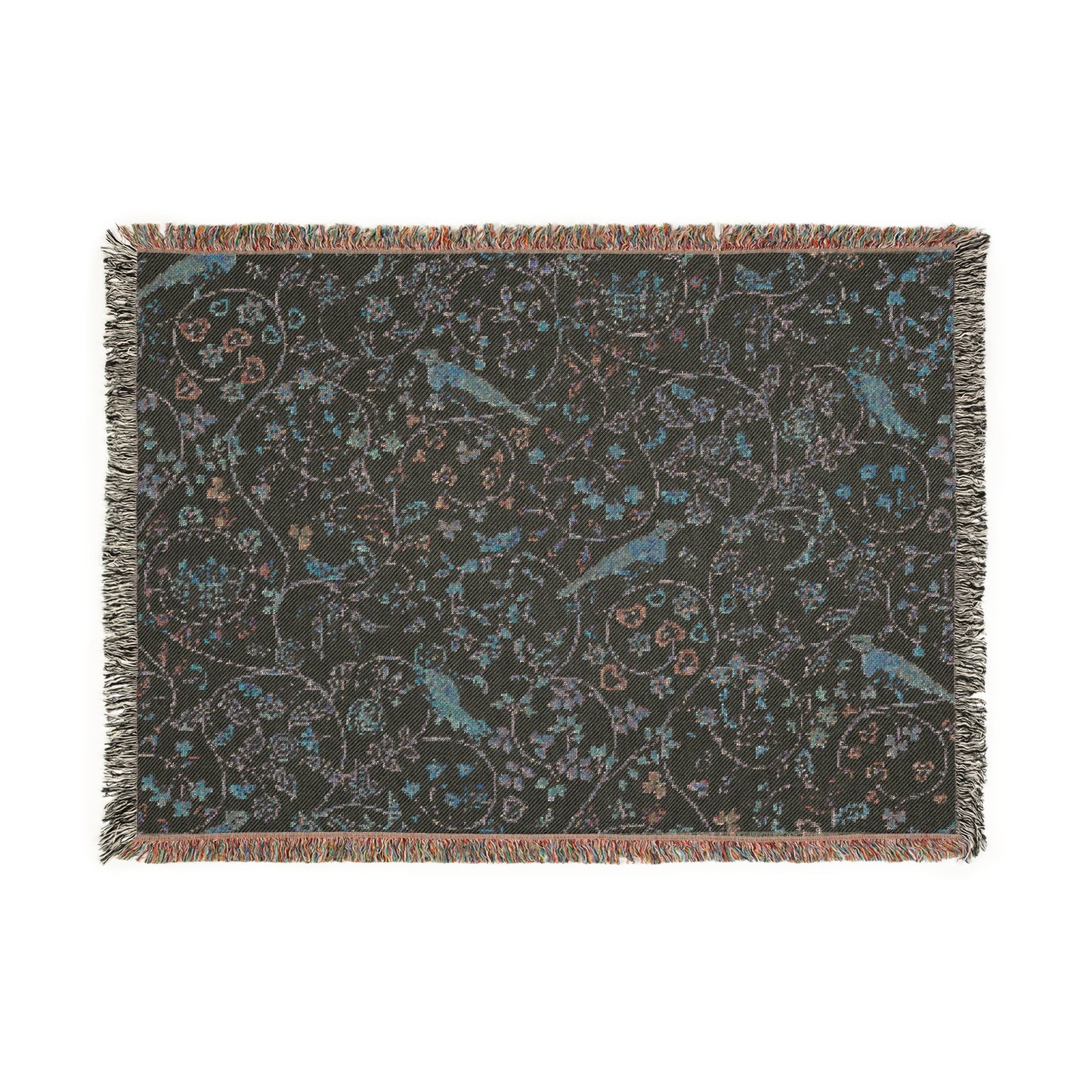 A beige woven cotton blanket with a William Morris & Co floral and bird pattern, featuring a colourful fringed edge.