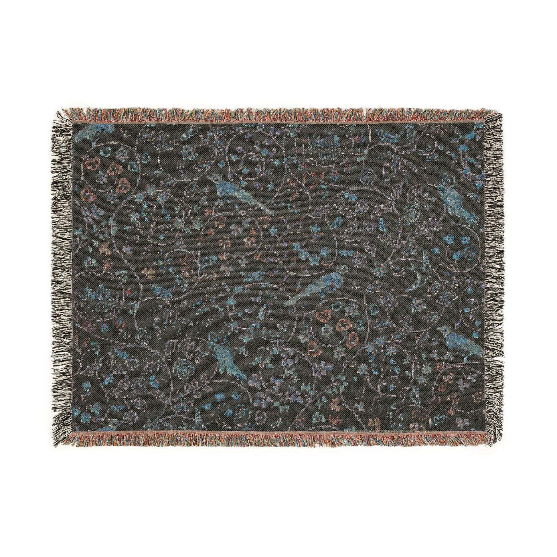 A beige woven cotton blanket with a William Morris & Co floral and bird pattern, featuring a colourful fringed edge.