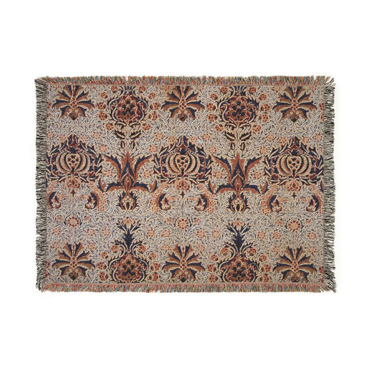 A woven cotton blanket with a geometric William Morris & Co pattern in shades of brown, beige, and black, with a colourful fringed edge.