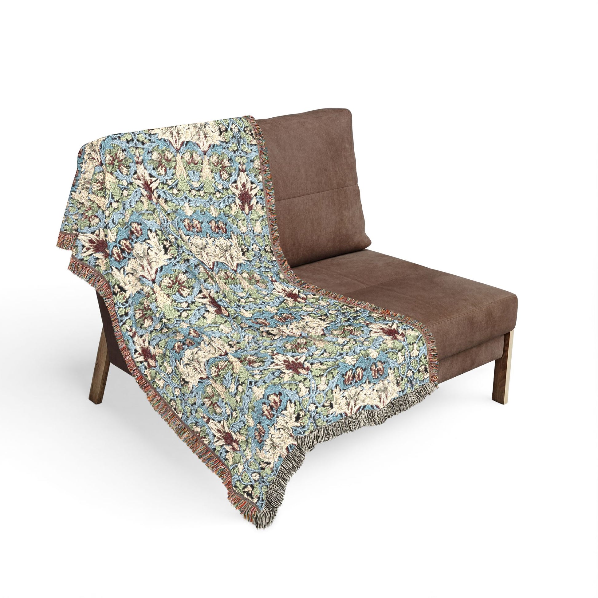 Floral-patterned throw blanket draped over a brown chair on a white background