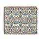 A woven blanket with a floral pattern in shades of blue, beige, and red with a fringed edge.