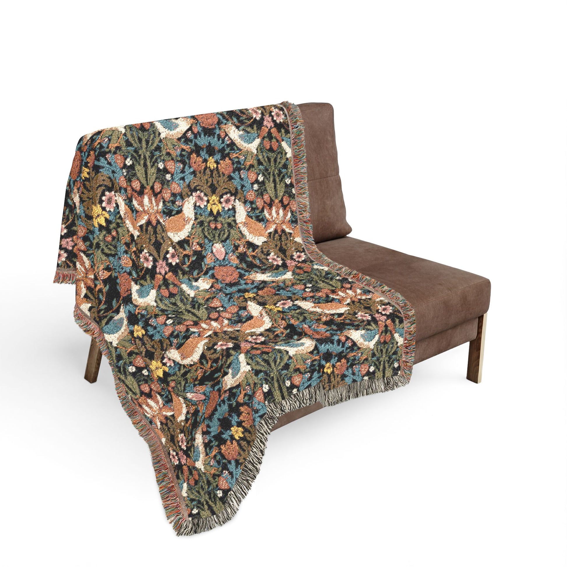 Floral patterned throw blanket draped over a brown chair on a white background