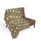 Decorative blanket with a floral pattern draped over a brown chair on a white background