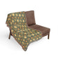 Brown chair with a green floral patterned throw blanket on a white background