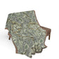 Geometric patterned blanket draped over a chair on a white background