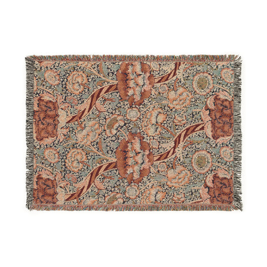 A woven cotton blanket with a geometric and floral William Morris & Co pattern in red, blue, beige, and brown colours, with fringed edges.