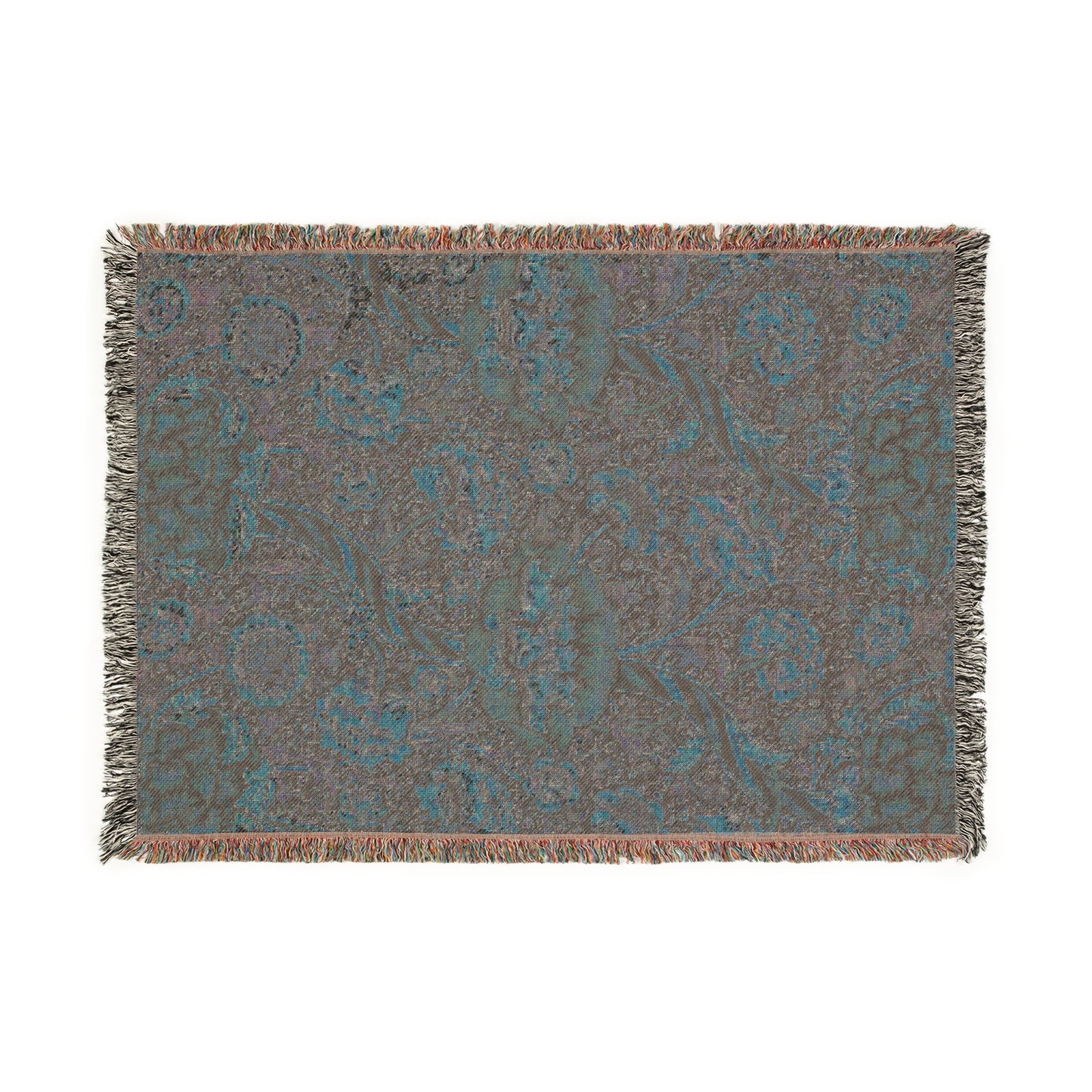 A woven cotton blanket with a geometric and floral William Morris & Co pattern in red, blue, beige, and brown colours, with fringed edges.