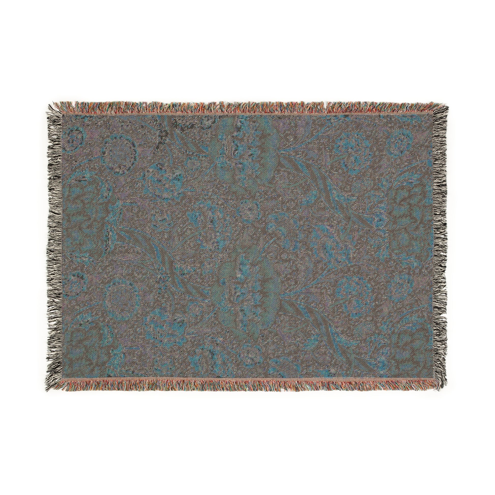 A woven cotton blanket with a geometric and floral William Morris & Co pattern in red, blue, beige, and brown colours, with fringed edges.