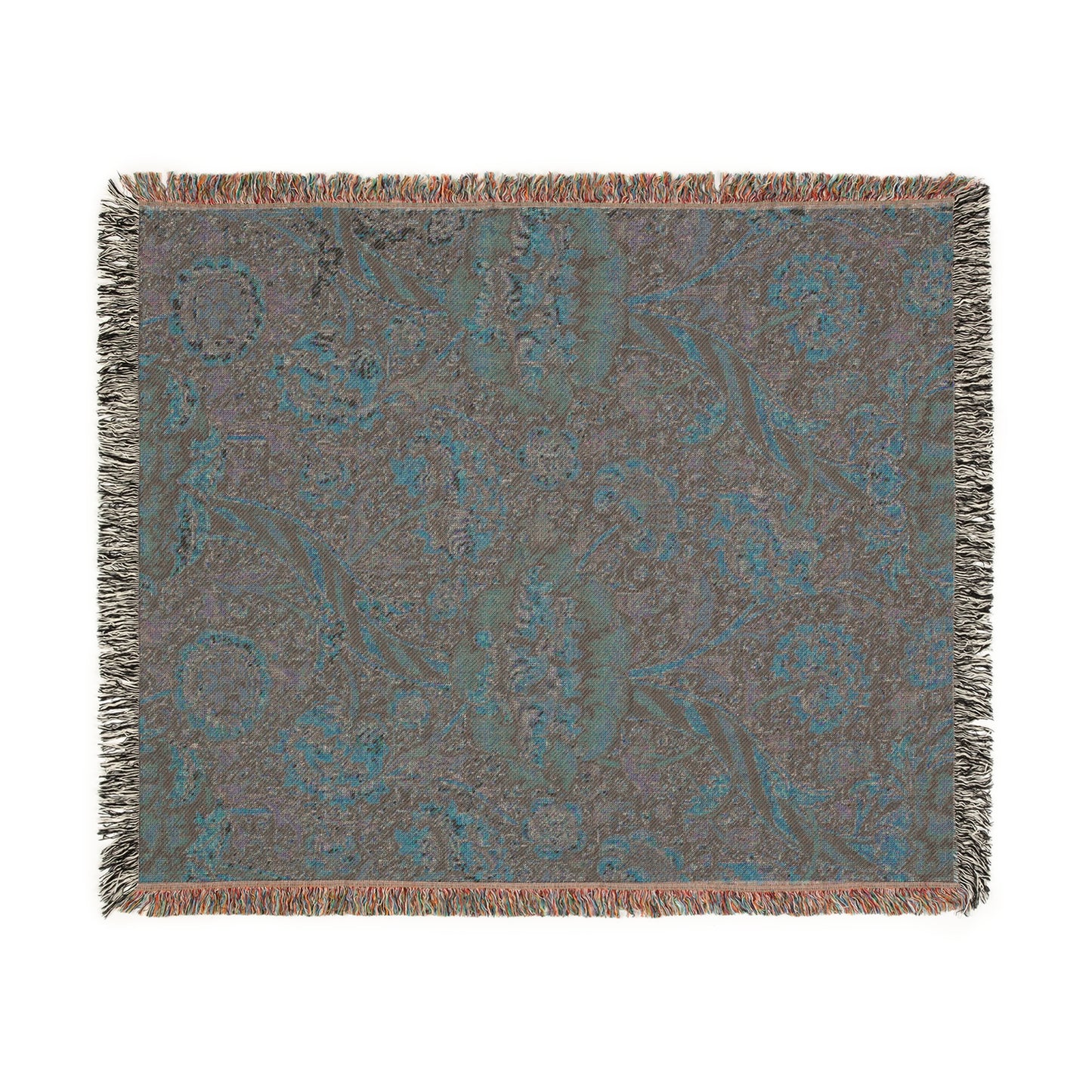 A woven cotton blanket with a geometric and floral William Morris & Co pattern in red, blue, beige, and brown colours, with fringed edges.