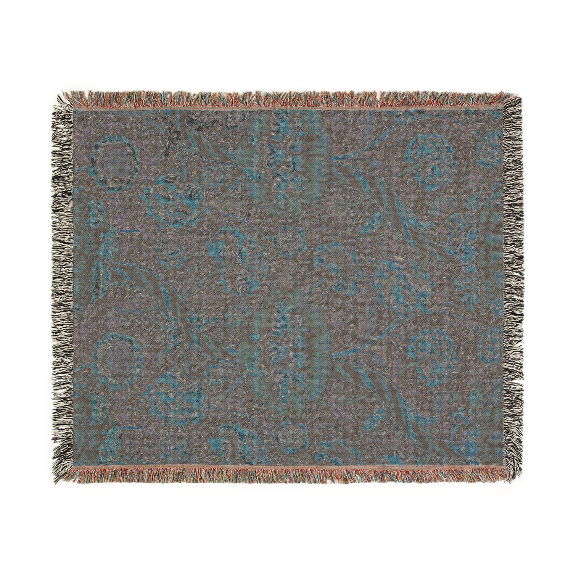 A woven cotton blanket with a geometric and floral William Morris & Co pattern in red, blue, beige, and brown colours, with fringed edges.