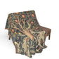 Decorative blanket with nature-themed design draped over a chair on a white background