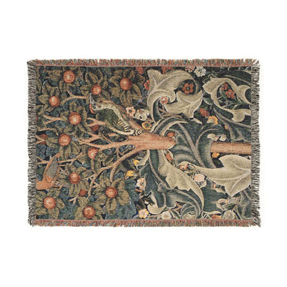 A woven cotton blanket with a William Morris & Co floral and bird pattern, featuring a colourful fringe.