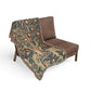 Brown chair with a decorative tapestry blanket featuring nature-themed design.