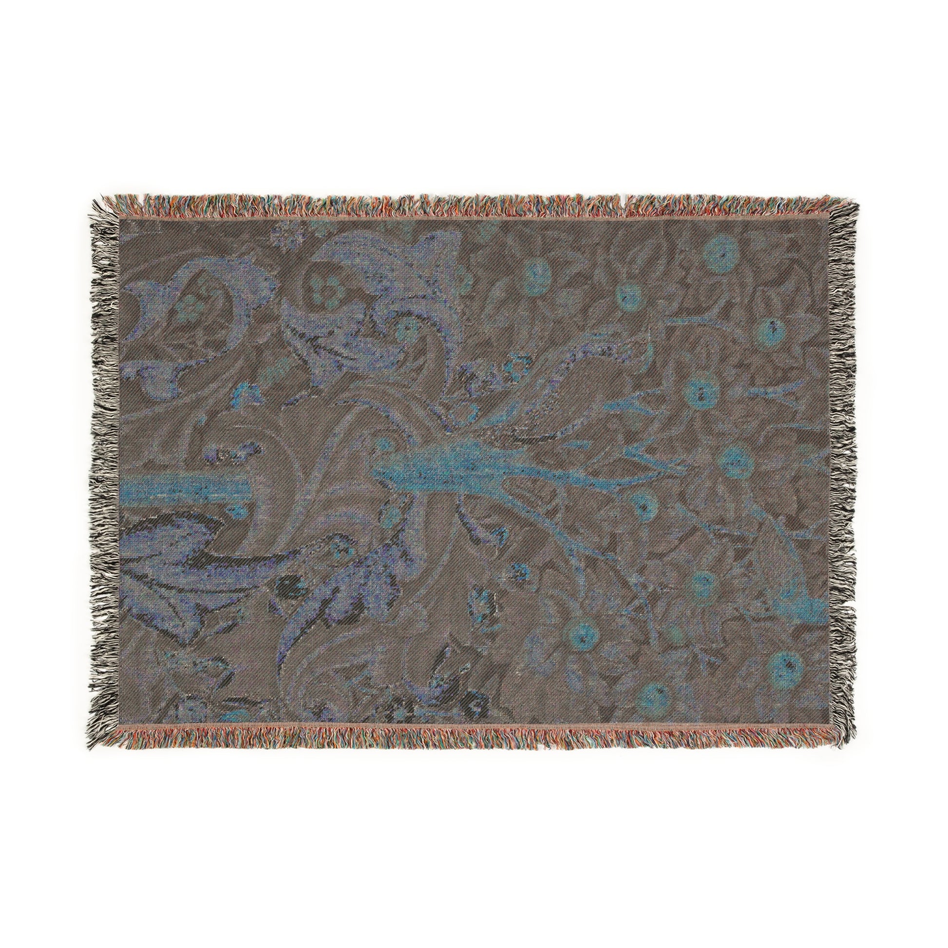 A woven cotton blanket with a William Morris & Co floral and bird pattern, featuring a colourful fringe.