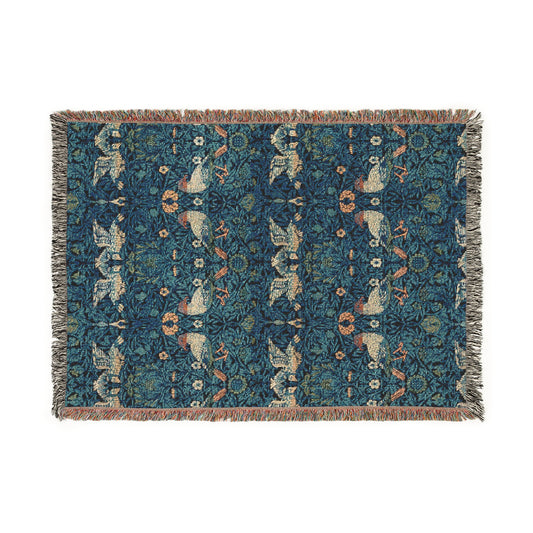 A woven cotton blanket with a geometric William Morris & Co pattern in shades of blue and a fringed edge.