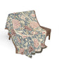 Floral patterned throw blanket draped over a chair on a white background