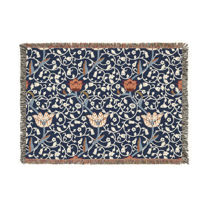 A woven cotton blanket with a geometric William Morris & Co pattern in blue, red and white colours, featuring fringed edges.