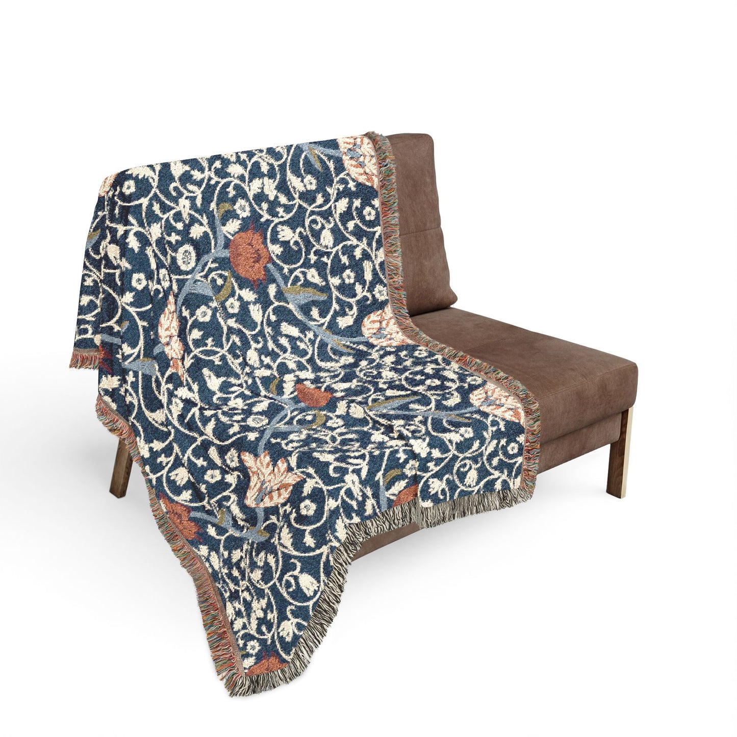 Floral patterned throw blanket draped over a brown chair on a white background