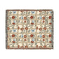 A woven cotton blanket with a geometric pattern featuring floral motifs and a colorful edge fringe.
