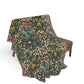 Floral patterned blanket draped over a chair on a white background