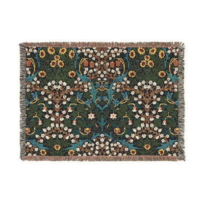 A woven cotton blanket with a floral William Morris & Co pattern in multiple colours, including green, blue, and red, with fringed edges.