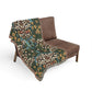Floral-patterned blanket draped over a brown chair on a white background