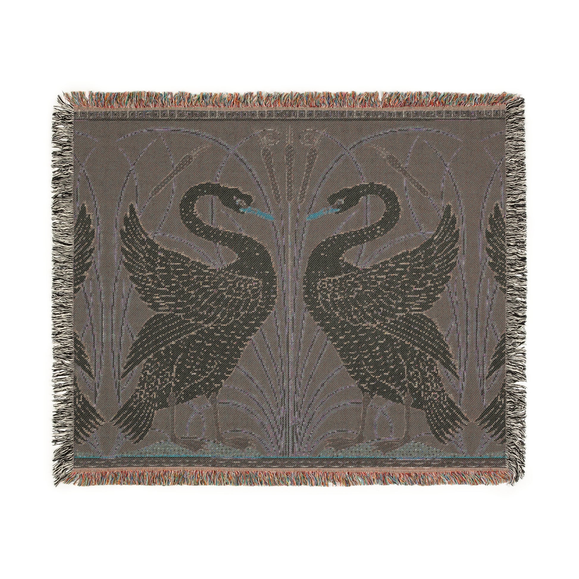 A woven cotton blanket with a geometric William Morris & Co pattern featuring swan motifs in a white and green colour scheme with colourful fringed edges.