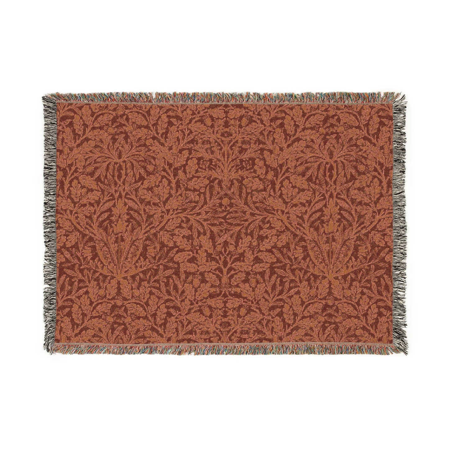 A woven cotton blanket with a floral William Morris & Co geometric pattern in a rust colour, featuring a colourful fringed edge.