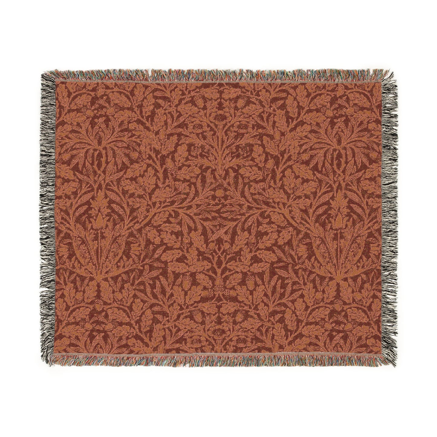 A woven cotton blanket with a geometric pattern in a rust color, featuring a colorful fringed edge.
