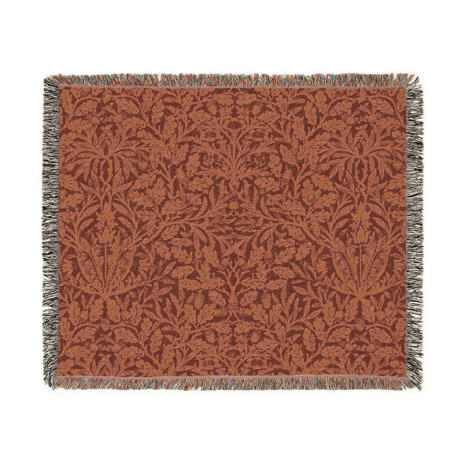 A woven cotton blanket with a geometric pattern in a rust color, featuring a colorful fringed edge.