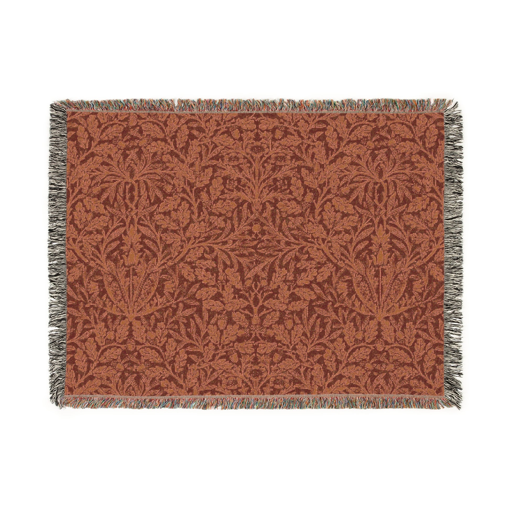 A woven cotton blanket with a geometric pattern in a rust color, featuring a colorful fringed edge.