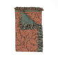 Patterned throw blanket with fringes on a white background