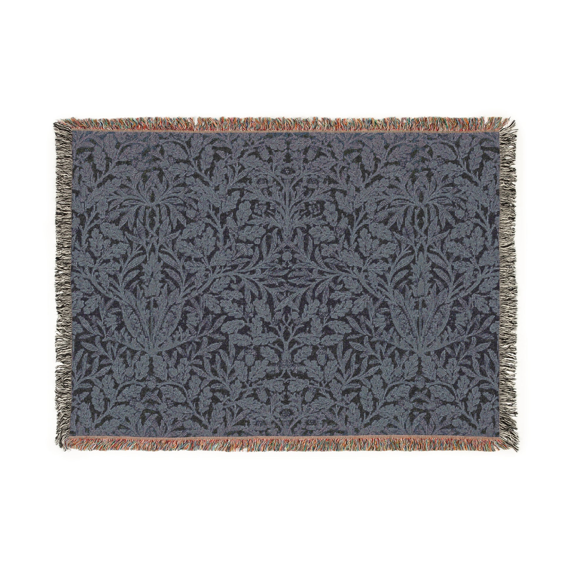 A woven cotton blanket with a geometric William Morris & Co pattern in smoky blue colour, featuring fringed edges.