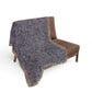 Gray patterned throw blanket draped over a brown chair on a white background