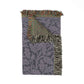Woven blanket with leaf pattern and fringed edges on a white background