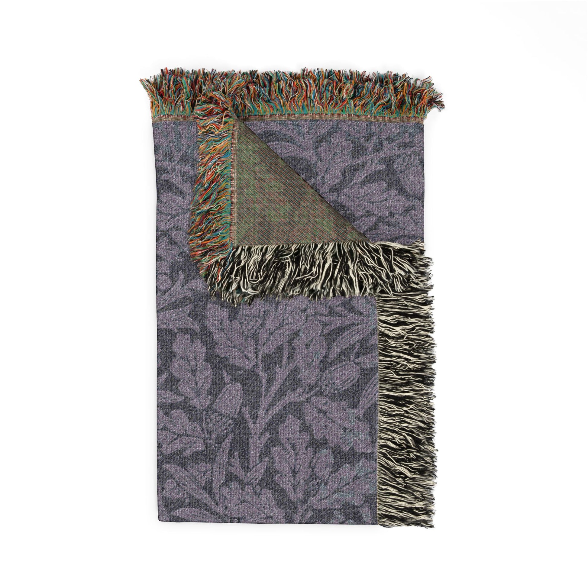 Woven blanket with leaf pattern and fringed edges on a white background