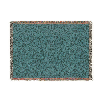 Teal patterned throw blanket with brown fringe on a white background