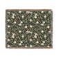 Floral patterned throw blanket with a green background on a white background