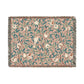 A woven cotton blanket with a floral pattern in shades of green and beige, featuring birds and pomegranate motifs, with a colorful fringed edge.