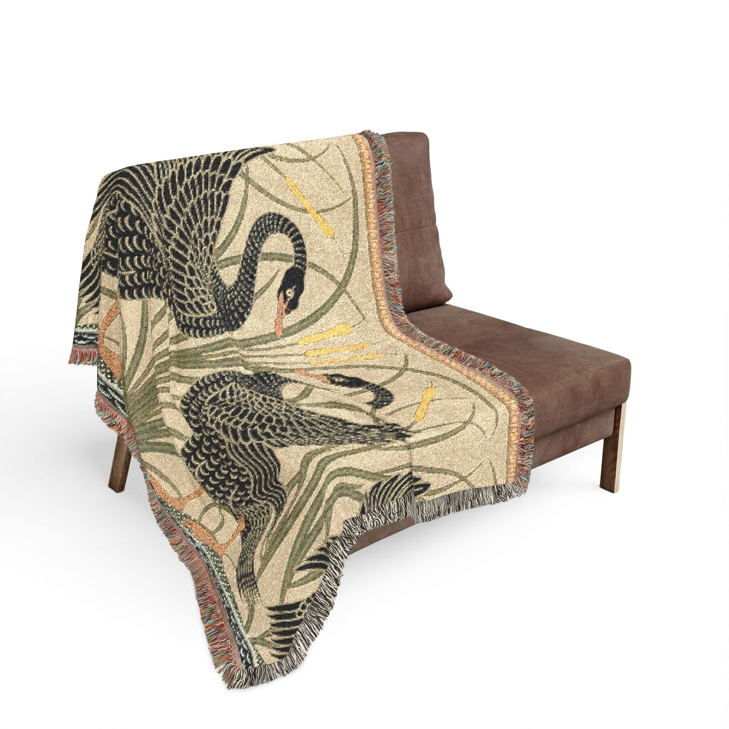 Decorative throw blanket with swan design draped over a brown chair on a white background