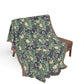Floral patterned blanket draped over a chair on a white background
