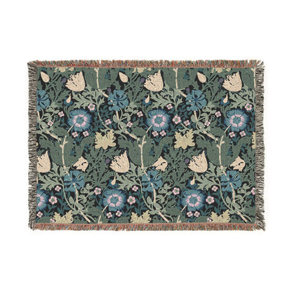 A woven cotton blanket with a floral William Morris & Co pattern in blue, green, and beige colours, featuring fringed edges.