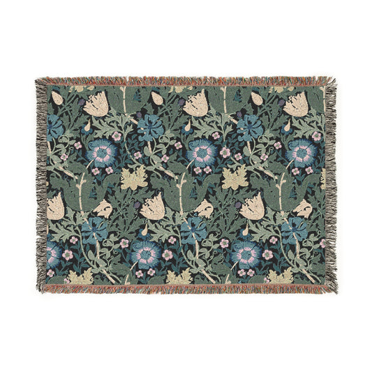 A woven cotton blanket with a floral William Morris & Co pattern in blue, green, and beige colours, featuring fringed edges.
