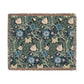 A woven cotton blanket with a floral pattern in blue, green, and beige colors, featuring fringed edges.